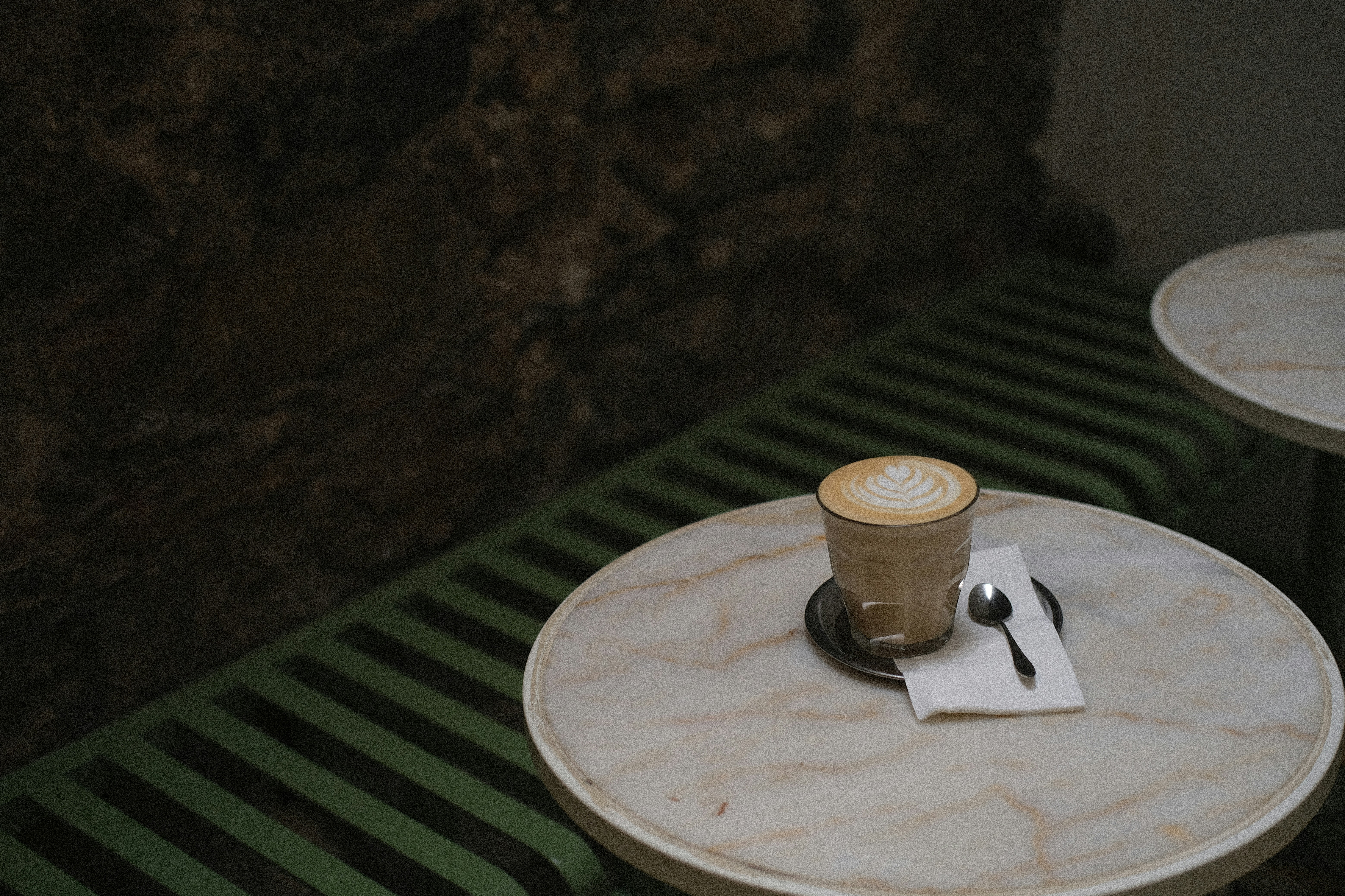 デザイン性の高いタンブラーとモバイルバッテリーが、カフェのテーブルに置かれている様子